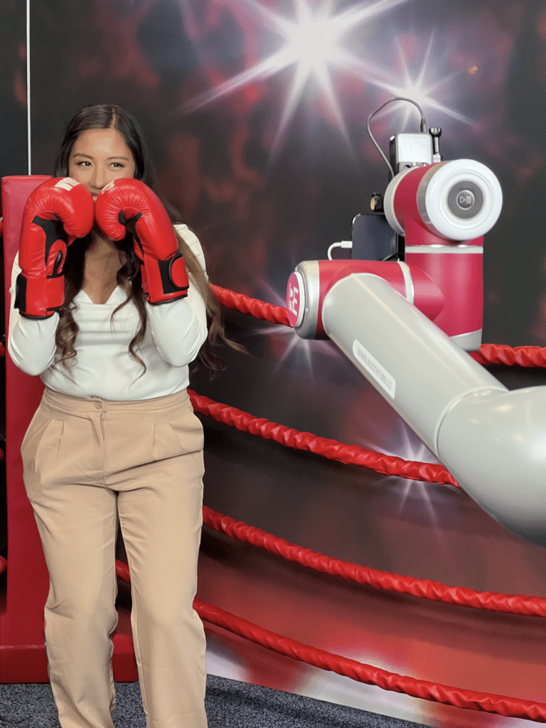 Glambot taking a shot fo a woman with boxing gloves