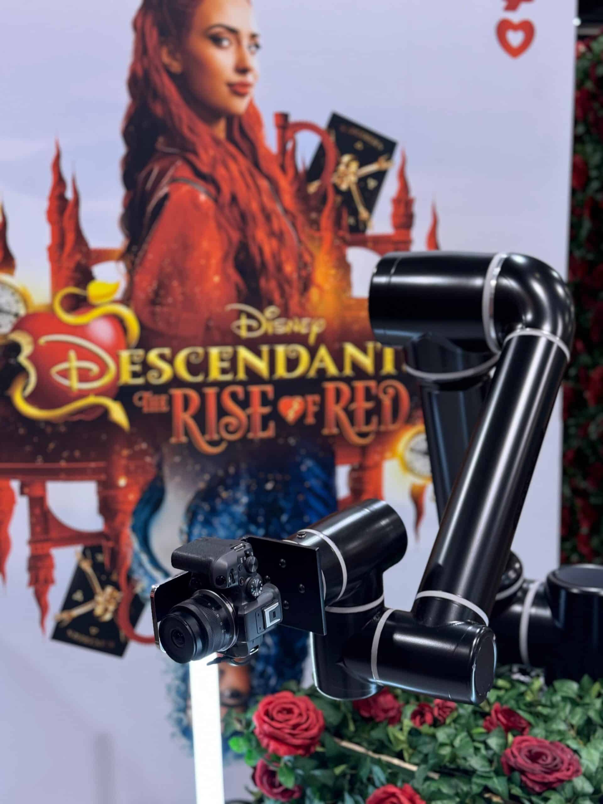 Photo of the Glambot in front of a Disney Decendants poster at VidCon 2024