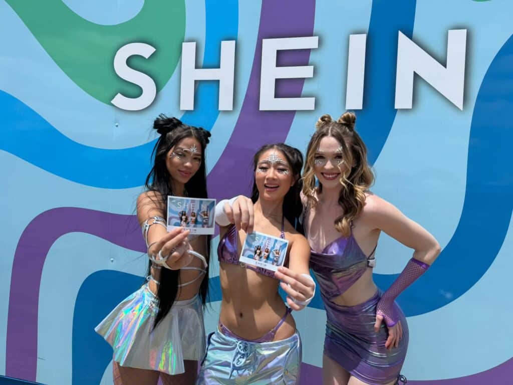 Three pretty grils holding their photos at the SHEIN x Breakaway festival