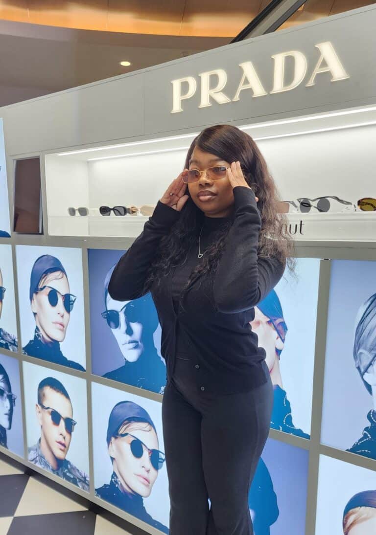 Girl posing in front of the Prada x Sunglass Hut Photo Booth