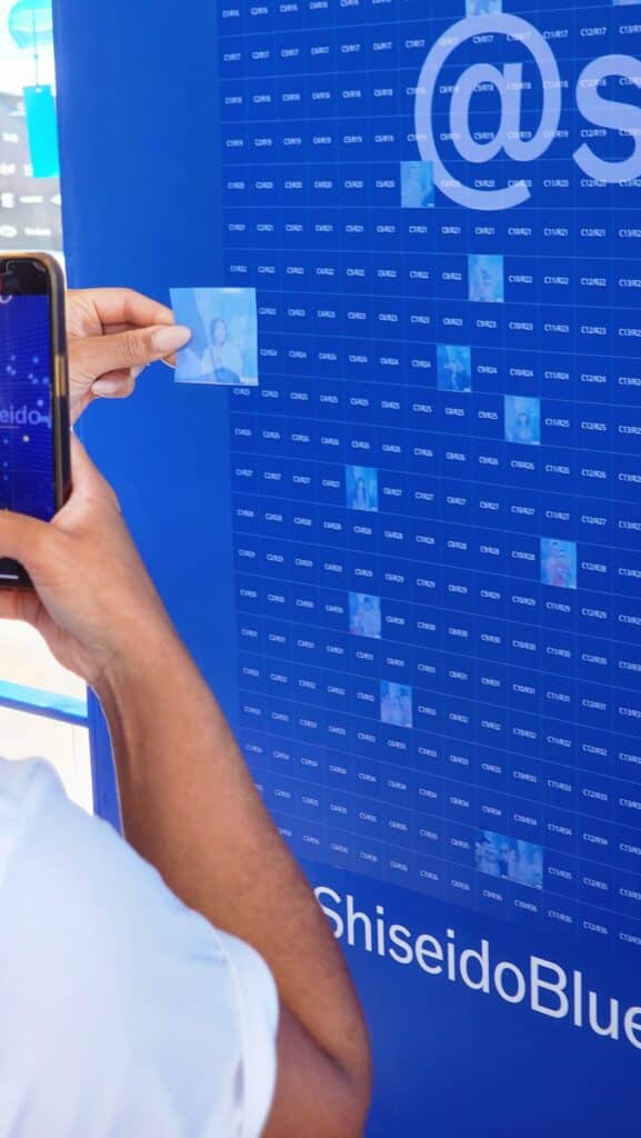 Someone taking a photo of their sticker for the photo mosaic wall