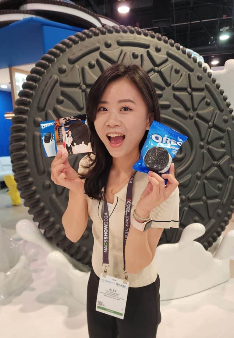 Young lady holding her just-talen picture on one hand and an Oreo Icecream on the other one.
