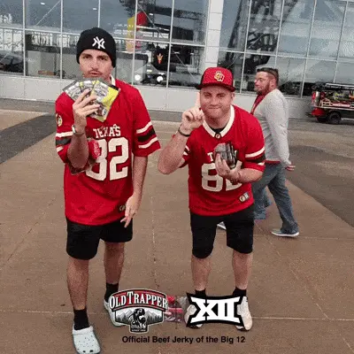 Two guys showing their beef jerky prodcuts to the Glambot Camera at Old Trapper Big 12