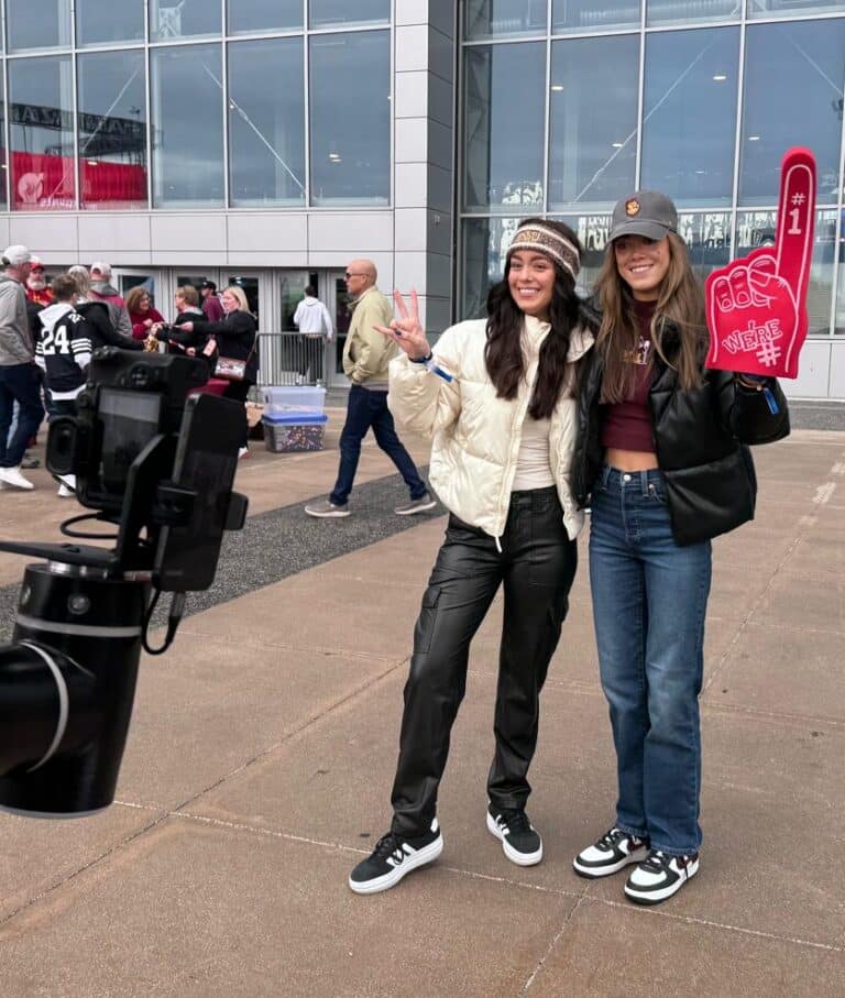 Two young ladis posing in front of the Glambot at the Old Trapper Big 12 Booth