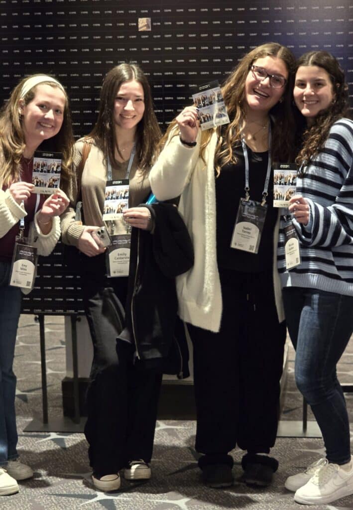 Group of young girls holding theirSeek 2025 pictures