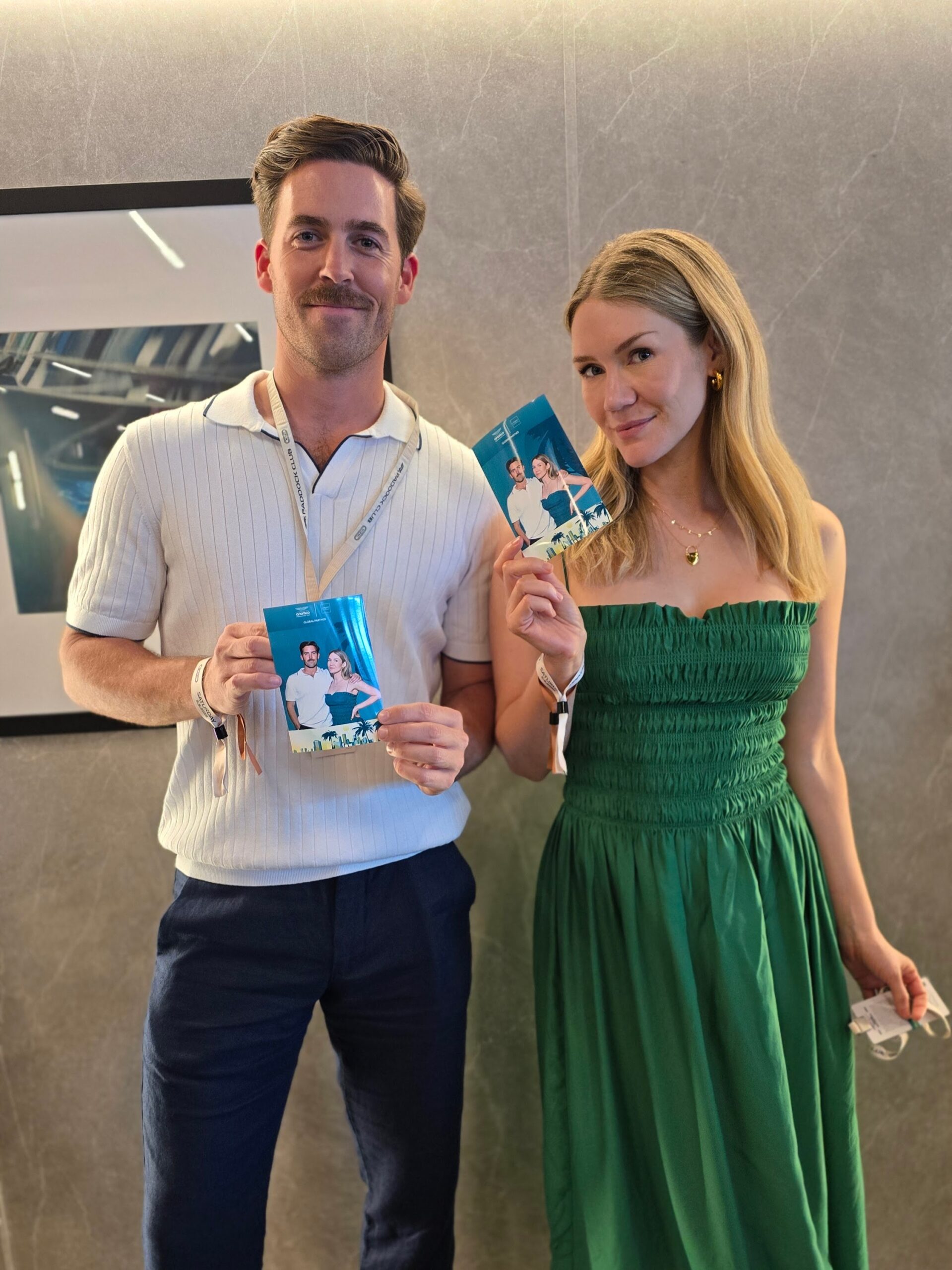 Couple at the Aston Martin Paddock Club holding their photo prints pf the Miami Grand Prix 2025