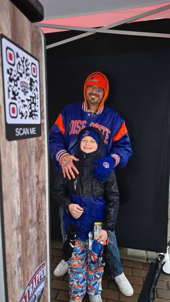 A dad and his son about to take a picture at the Boise State Vs. UNLV game
