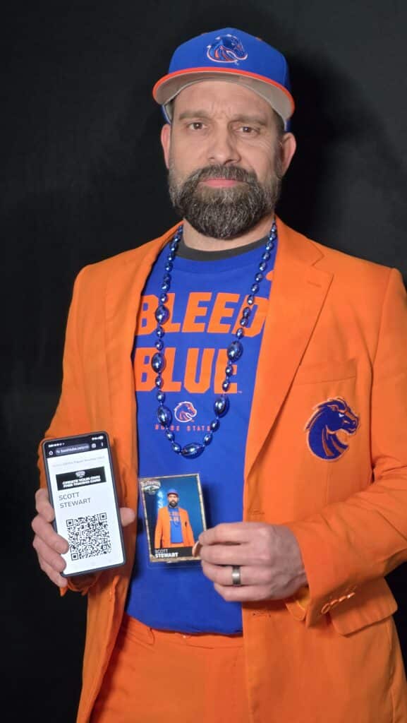 A gentleman holding is Trading Card and his QR code at the Boise State Vs. UNLV game