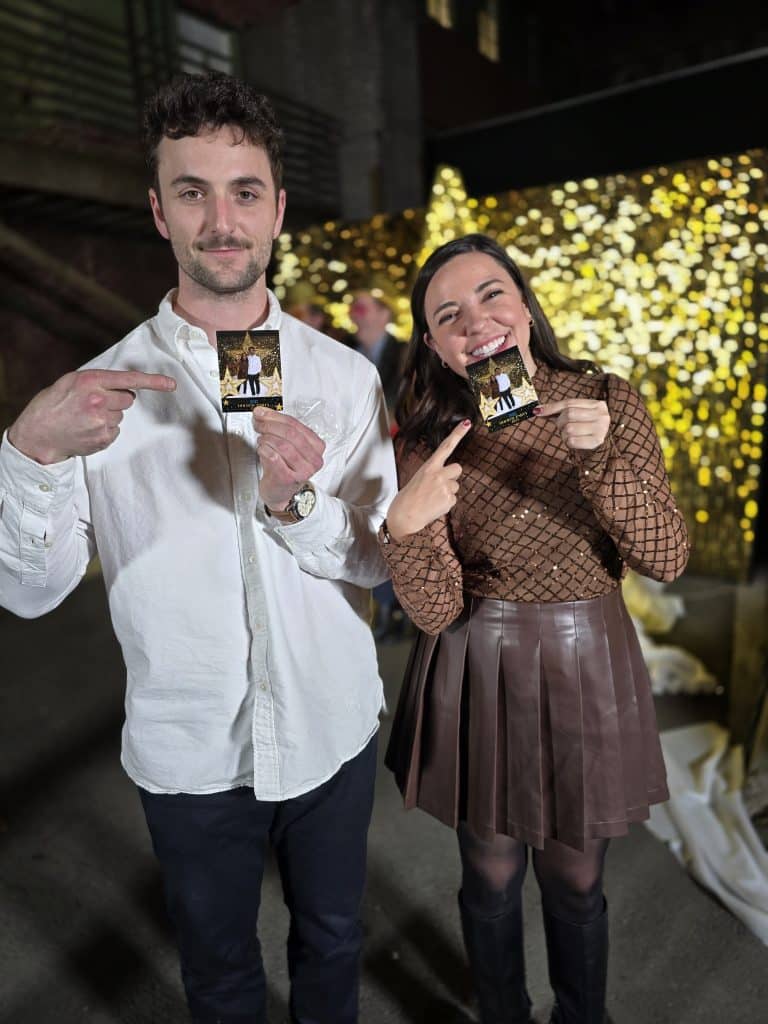 Couple happily holding their photo prints at the Fox Holiday Party 2025