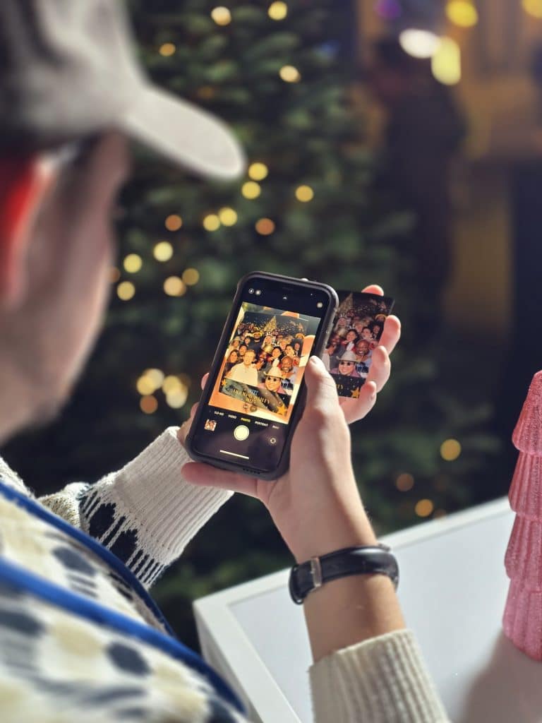 A person taking a picture of their photo print at Fox Holiday Party 2025