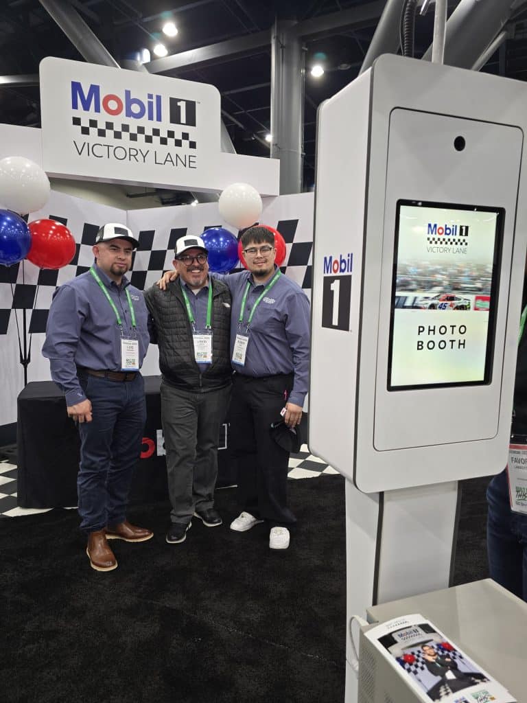 Three guys standing in front of the Mobil 1 Photo Booth at O'Reilly Leadership Conference 2026