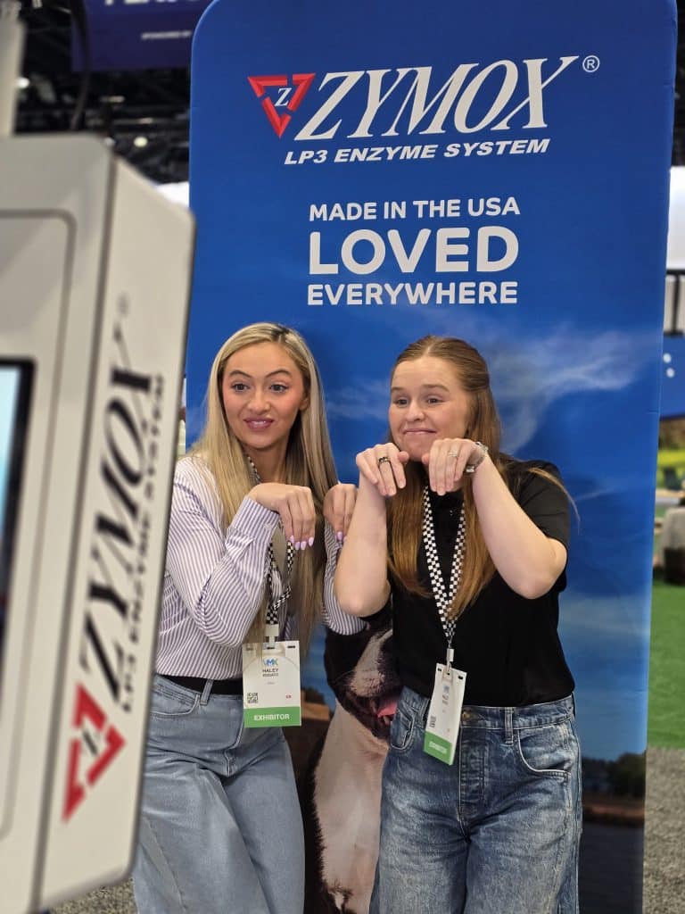 VMX 2026 Photo 6 Two girls posing like acat in front of the VMX 2026 Zymox Photo Booth