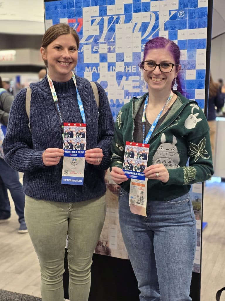 VMX 2026 Photo 3 Two ladies in front of the uncompleted photo mosaic wall holding their photo prints at VMX 2026