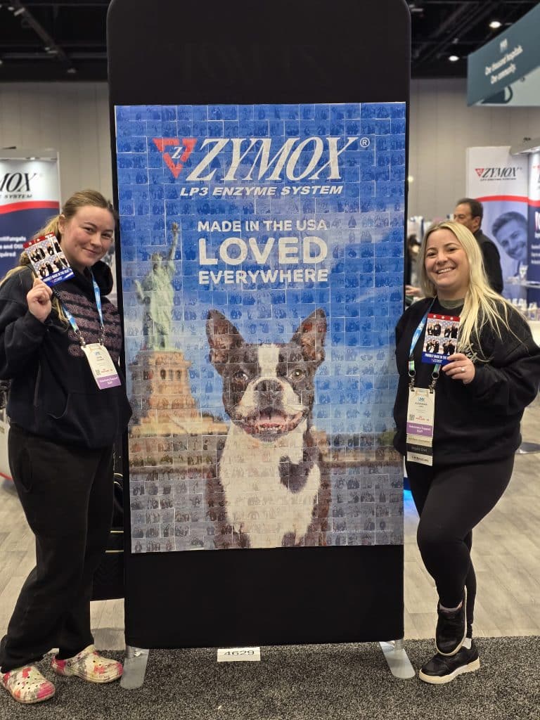 VMX 2026 Photo 8 Two women posing in front of the Zymox Photo Mosaic wall fully completed at VMX 2026