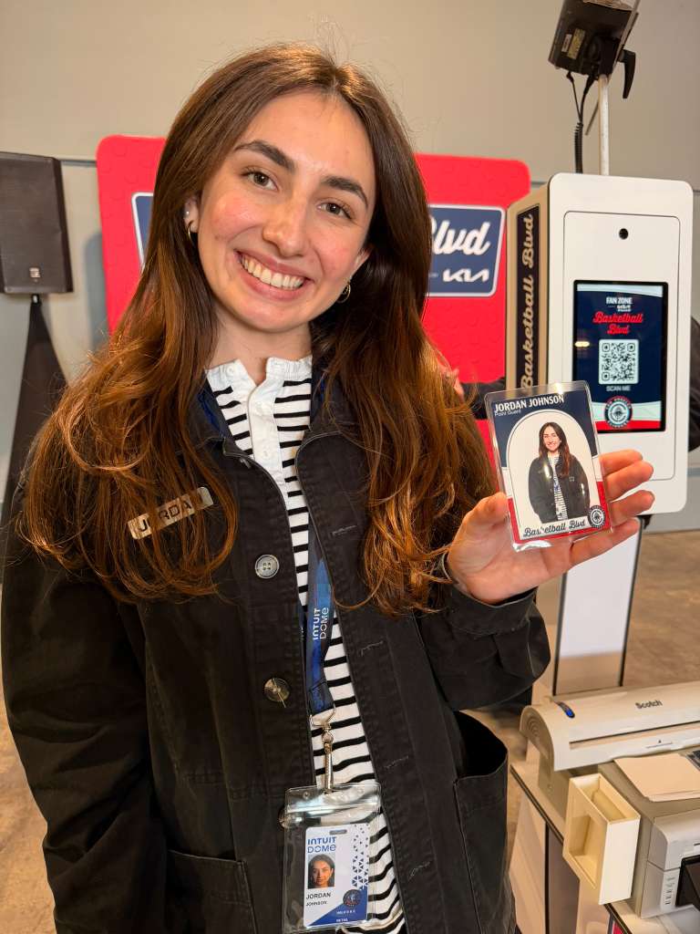 A young woman holding her LA Clippers trading card at NBA All star 2026