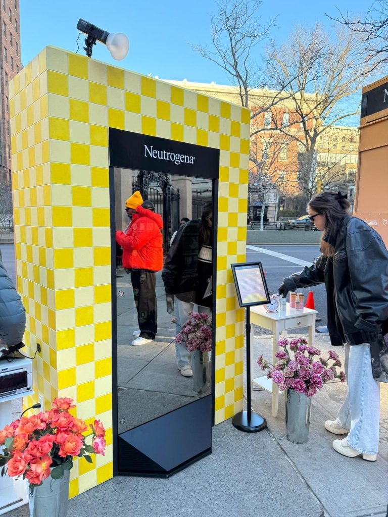 A lady looking at the Magic Mirror next to the Neutrogena Pop-uo store in nyc