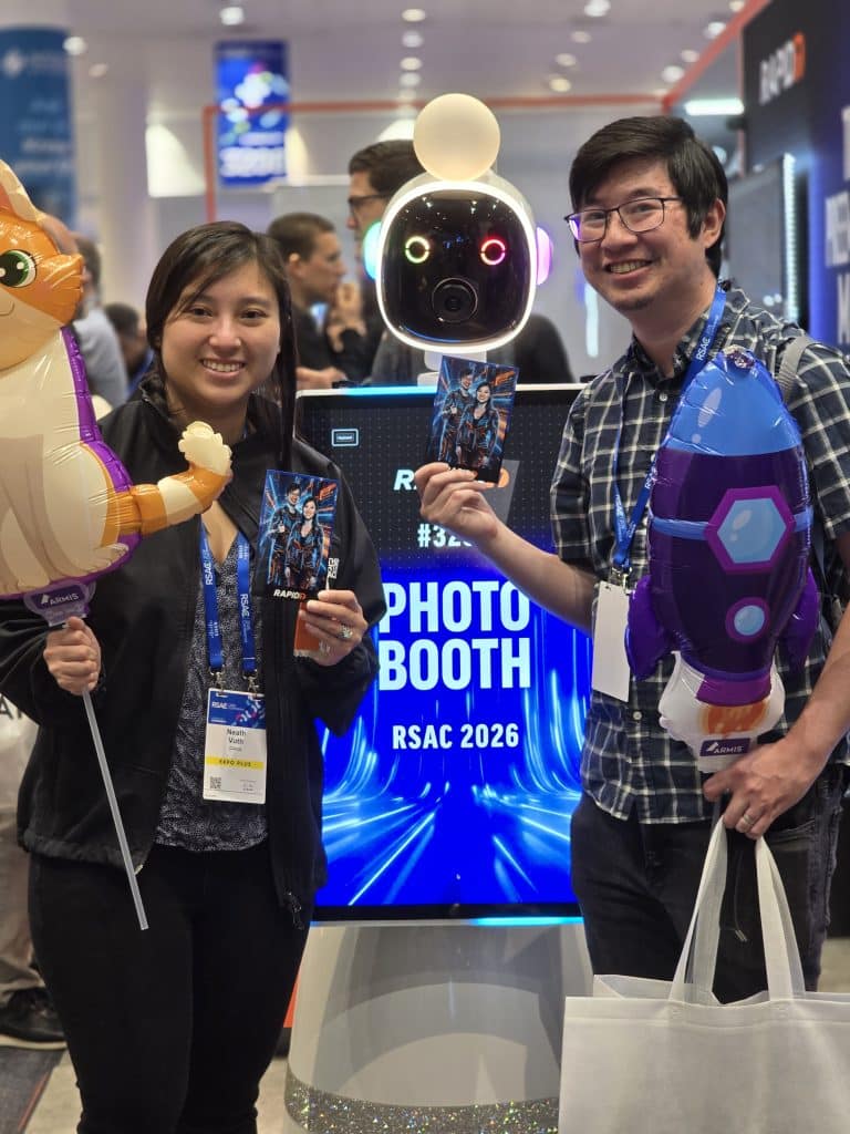 A happy couple holding their photo prints next to the Roaming Photo Bot
