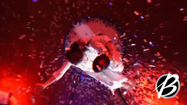 Gif of people moving inaishe the 360 photo booth while confetti rains around them