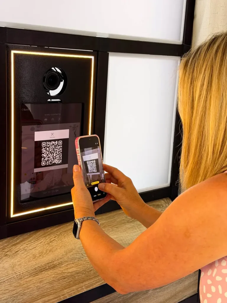 enclosed-booth2026-27 Person Scanning her picture QR code to share it isntantly to her phone