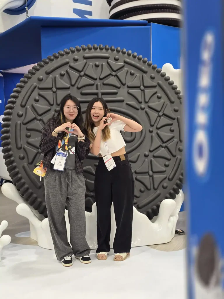 Two ladies posing in front of the big oreo before their photo is taken.